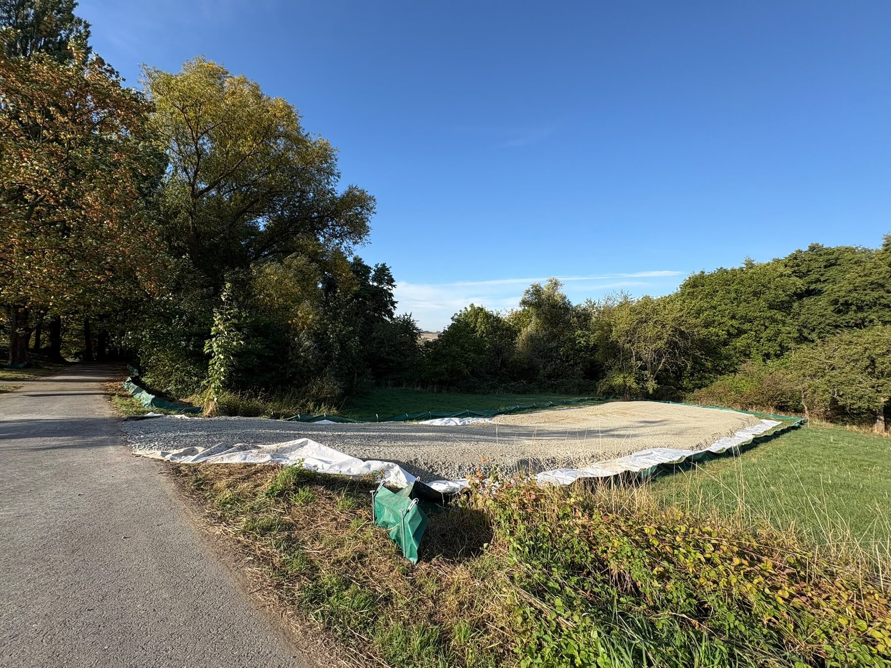 Geschotterter Bohrplatz ohne Maschinen neben einem Weg in Breckenheim