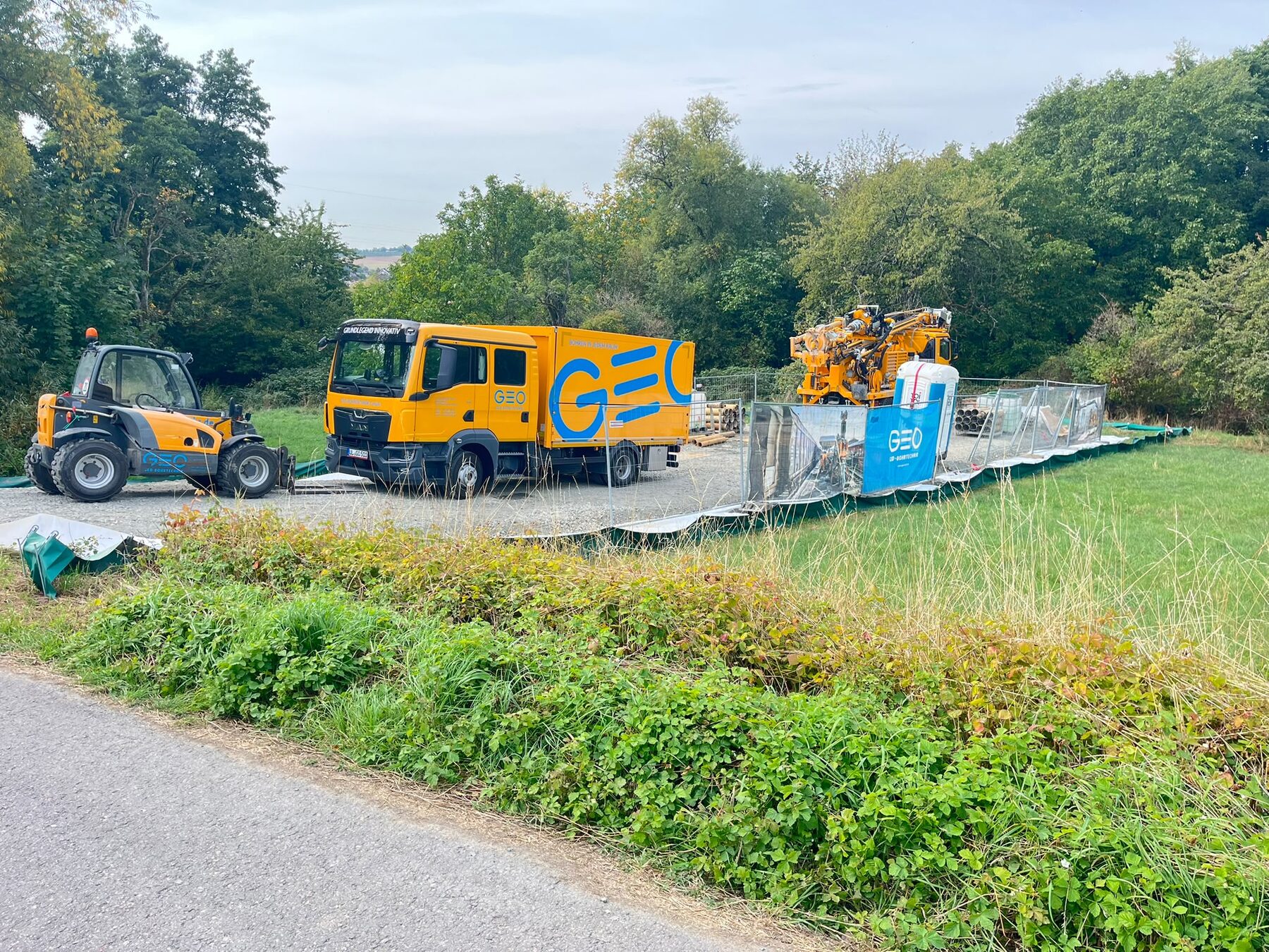 Bohrgerät, Lastwagen und Radlader auf einem eingezäunten Bohrplatz in Breckenheim